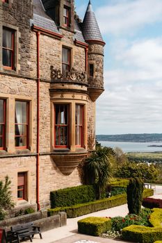 Stunning view of Belfast Castle with lush gardens and scenic waterfront in Northern Ireland.