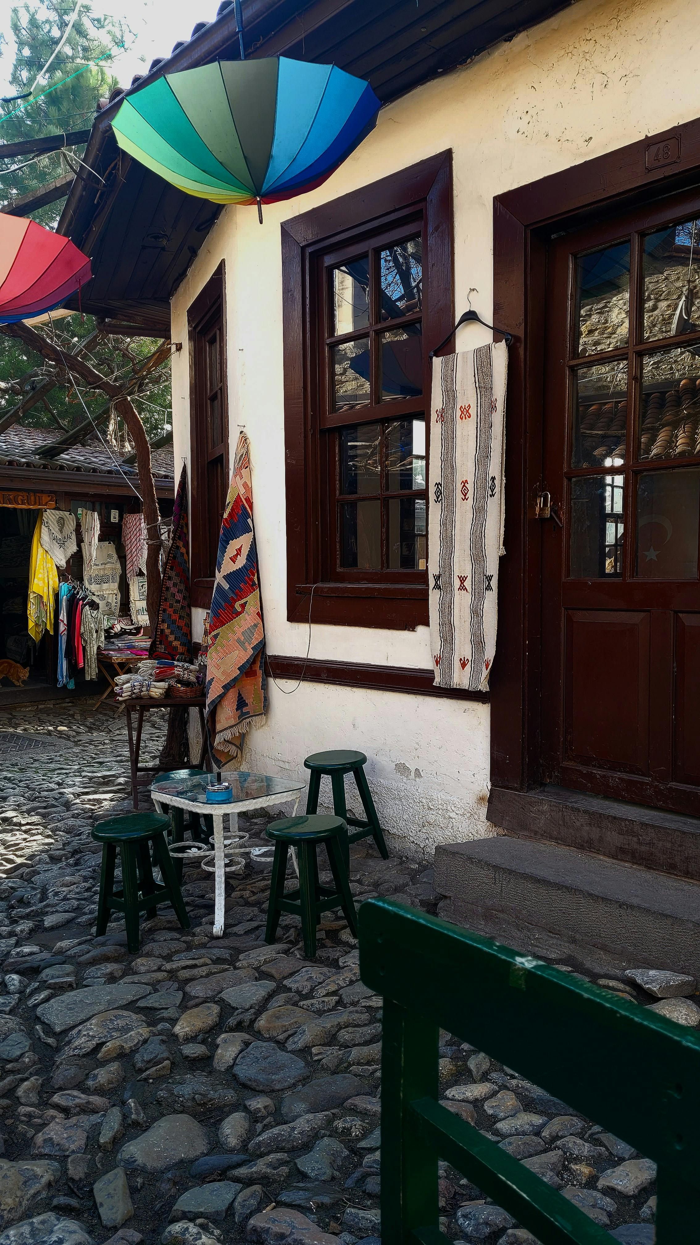 Colorful umbrellas and traditional decor in a cobblestone street in Safranbolu, Türkiye.