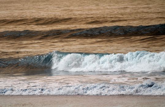 Gentle ocean waves crash at Guaratuba Beach, Brazil during daytime.