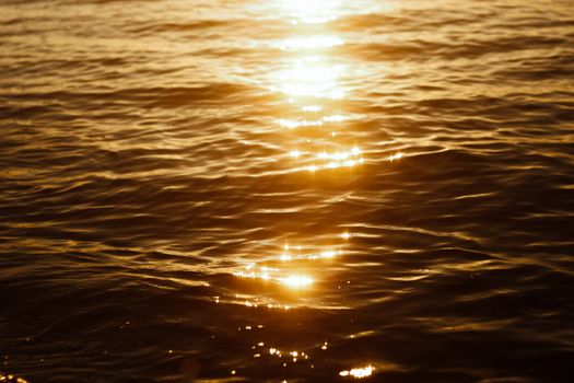 Capture of golden sunlight shimmering on calm sea waves at sunset in Egypt.