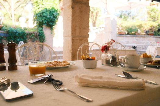 Elegant outdoor brunch with a rustic French decor. Includes fresh juice, pasta, and elegant tableware.