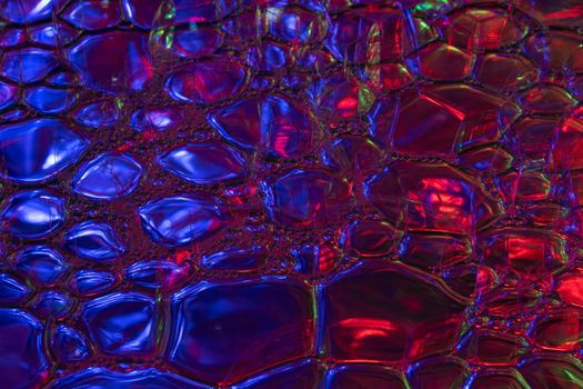 Colorful abstract image featuring blue and red glossy bubbles creating a vibrant texture.