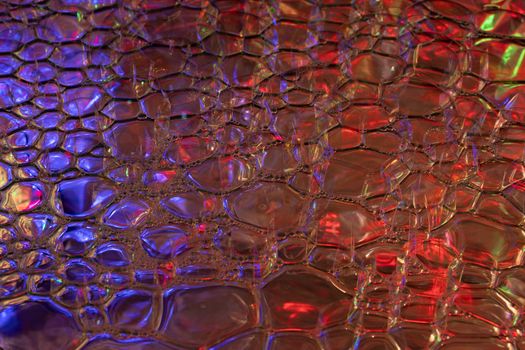 Vibrant abstract pattern featuring neon hues of red and blue with a glossy, textured surface.