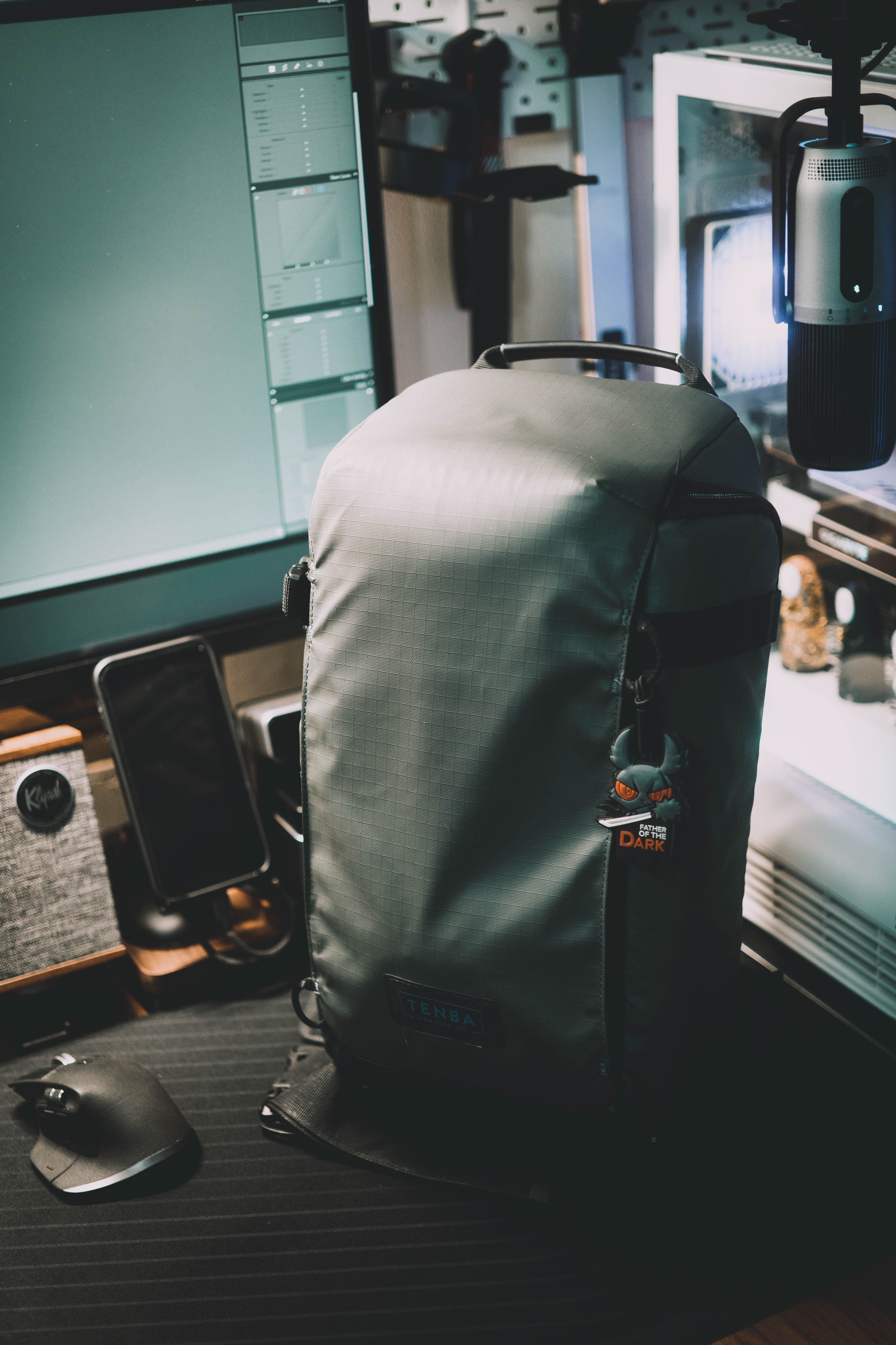 Cozy home office with a computer desk, backpack, and microphone, ideal for content creators.