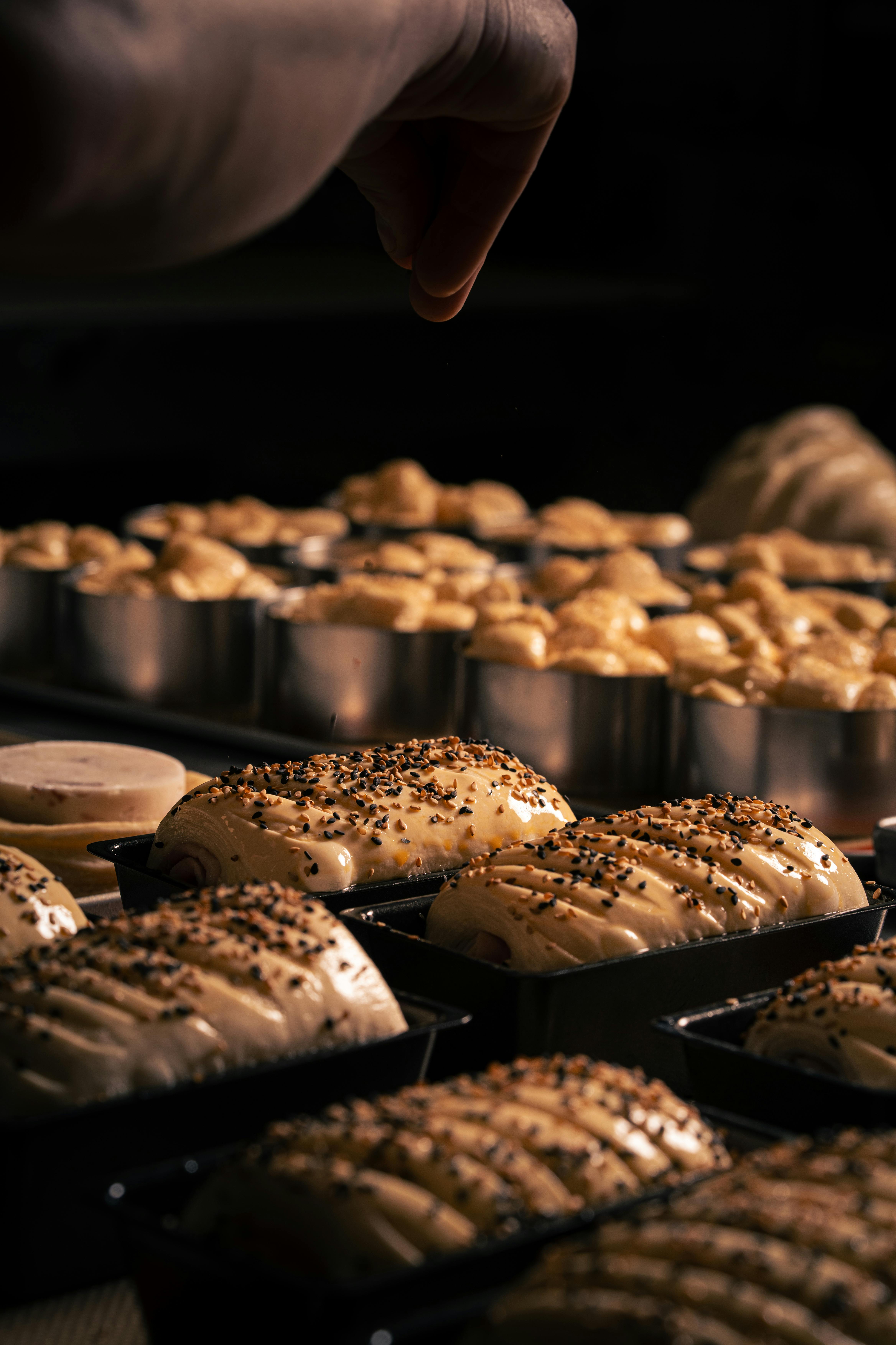 Freshly prepared artisan bread dough sprinkled with seeds, ready for baking in a professional bakery setting.