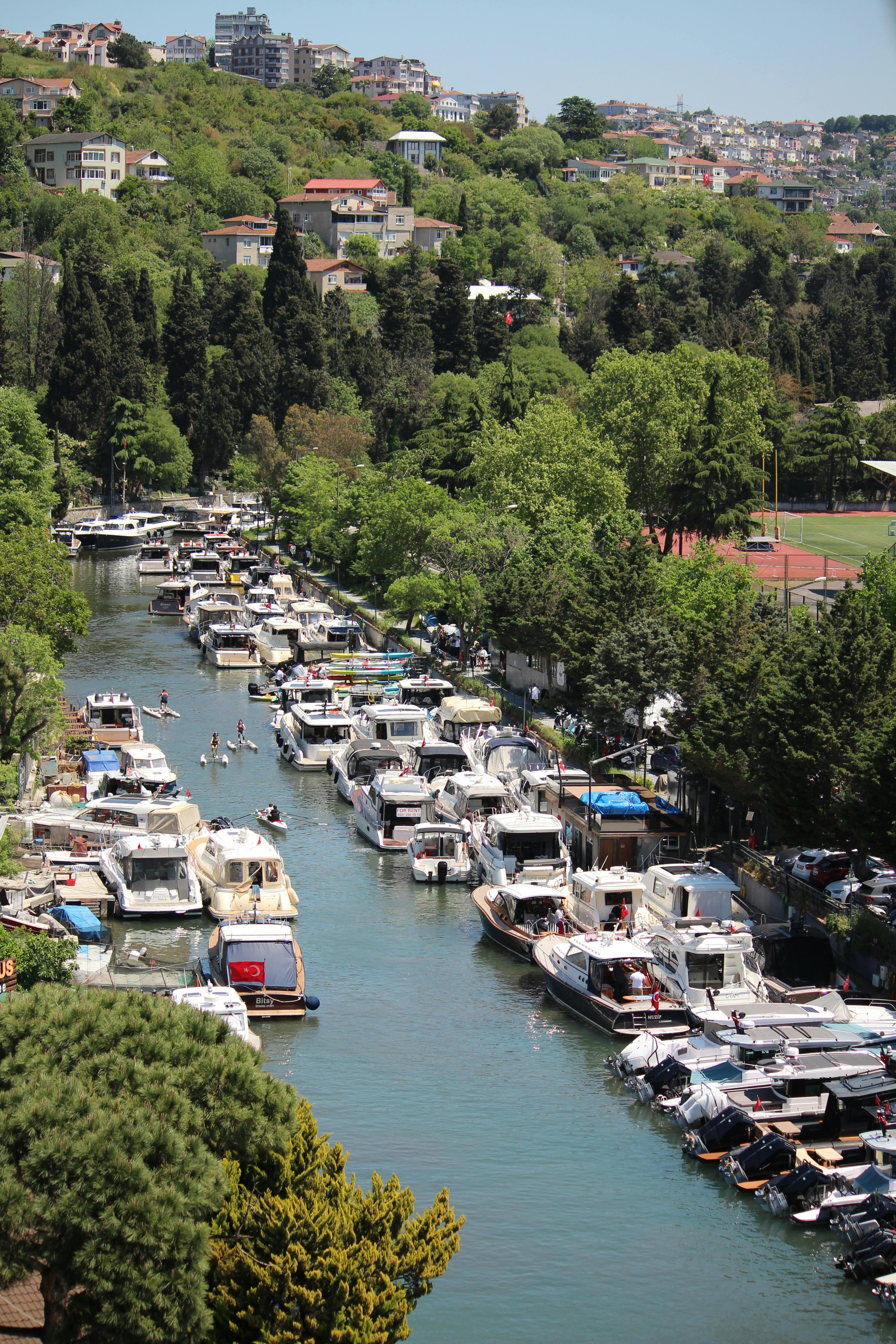 Aerial view of boats in Göksu River, Istanbul, with lush greenery along the banks.