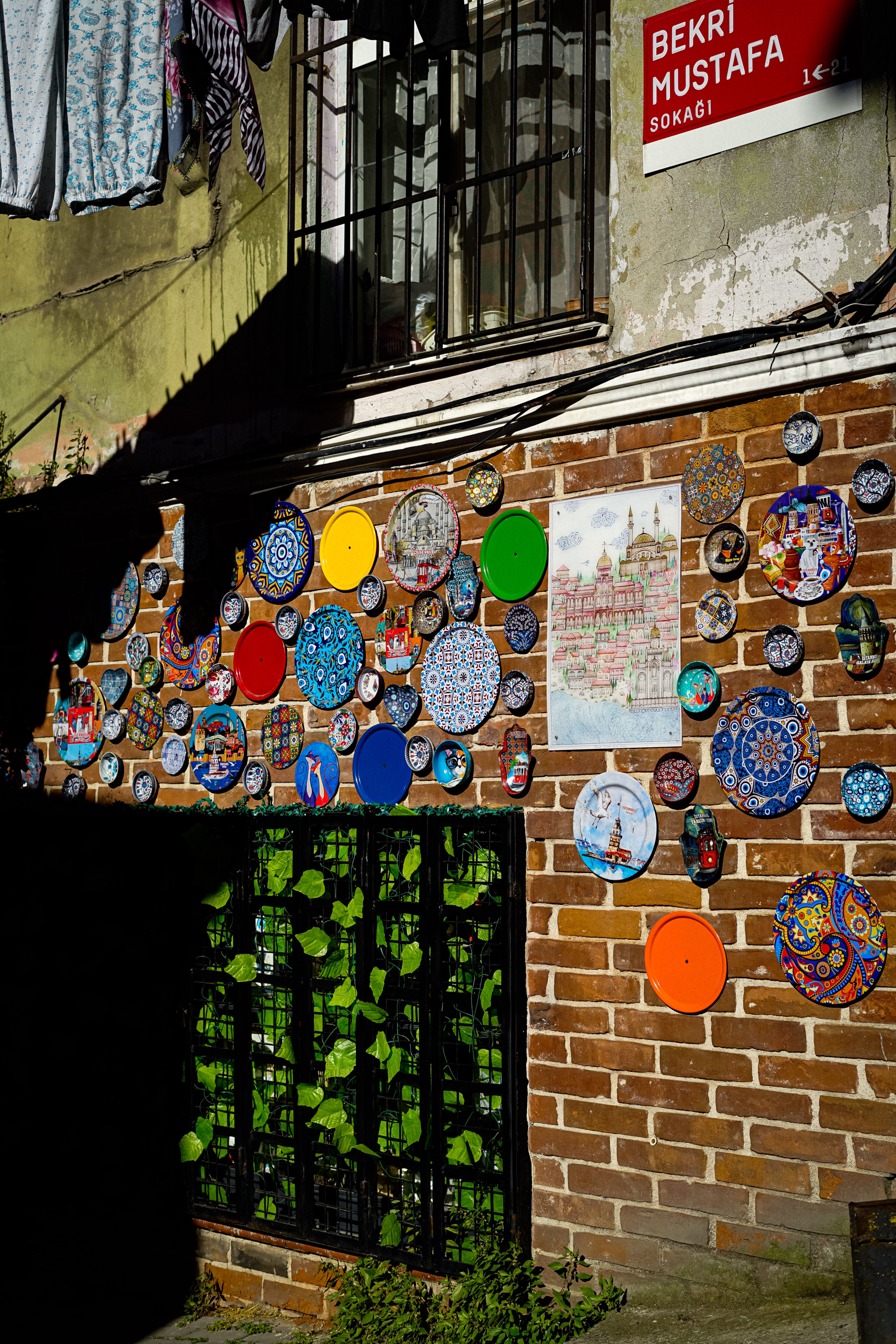 Vibrant ceramic plates decorate a brick wall under sunlight in Istanbul.