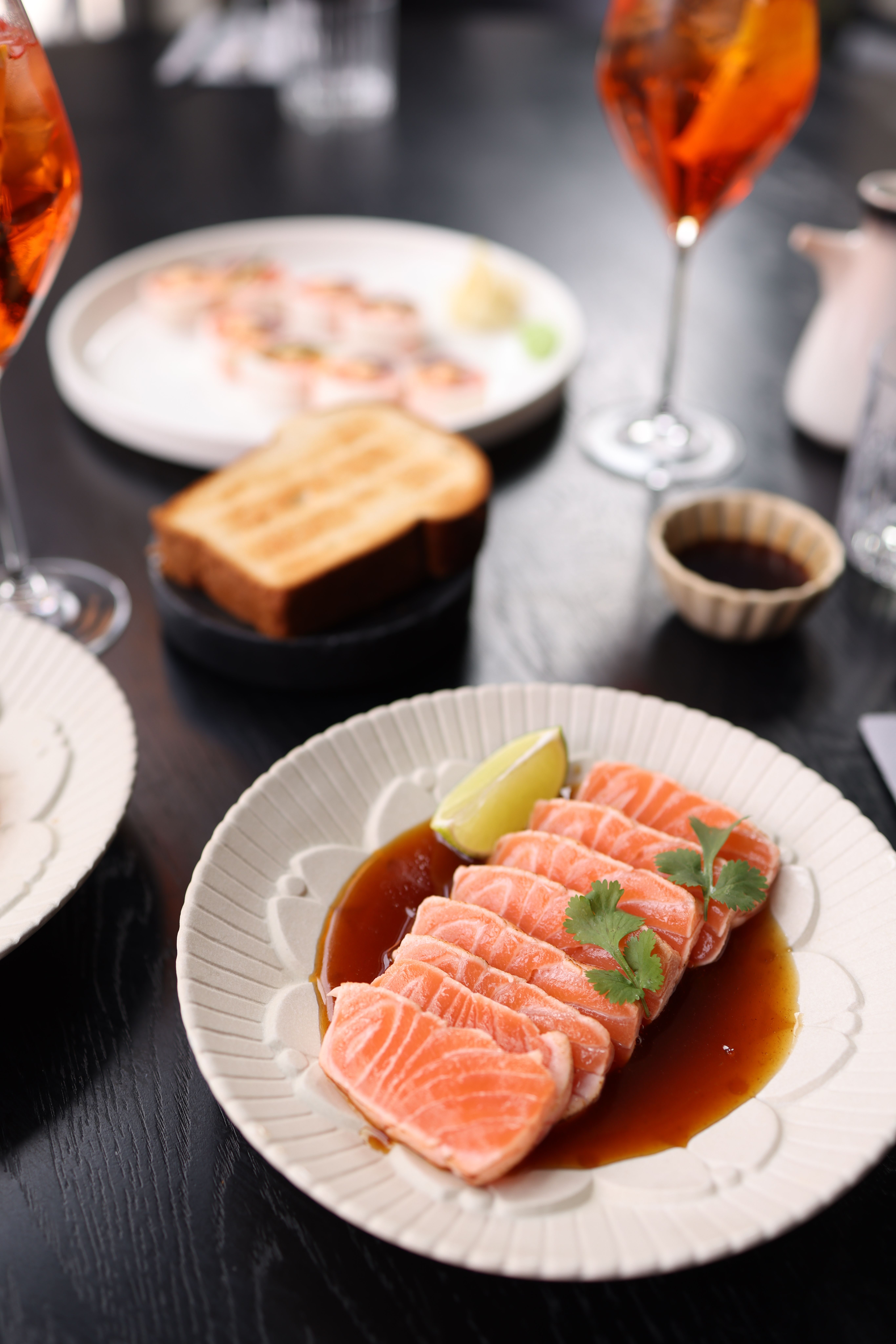 Delicious salmon sashimi on a plate with garnish, perfect for a gourmet meal setting.