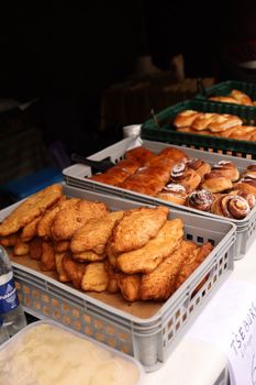 Delicious variety of pastries and breads on a market stall, offering a tasty selection for customers.
