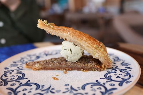 Free Close-up of a slice of baklava topped with ice cream on a blue and white decorative plate. Stock Photo