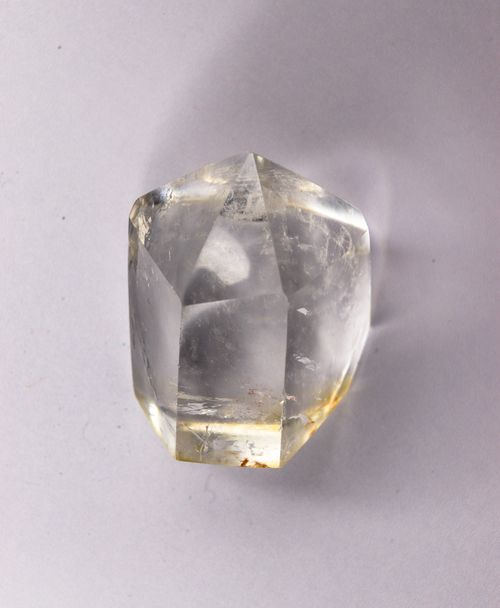 Free Clear quartz crystal with unique hexagonal shape, reflecting light on a gray backdrop. Stock Photo