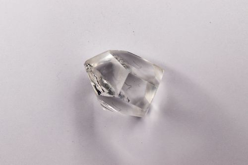Free A clear quartz crystal on a soft light background with delicate shadows, ideal for gemstone and healing themed visuals. Stock Photo