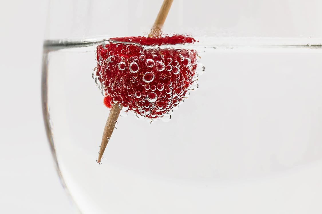 бесплатная Красная малина на воде с коричневой палочкой Стоковое фото