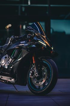 Sleek black motorcycle parked outdoors at dusk, showcasing modern design and performance.