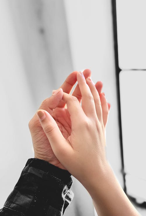 Two Person's Hands Holding Each Other
