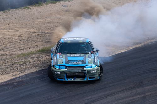 Free Capture the thrill of a high-speed car drift with a dramatic smoke trail on a racing track. Stock Photo