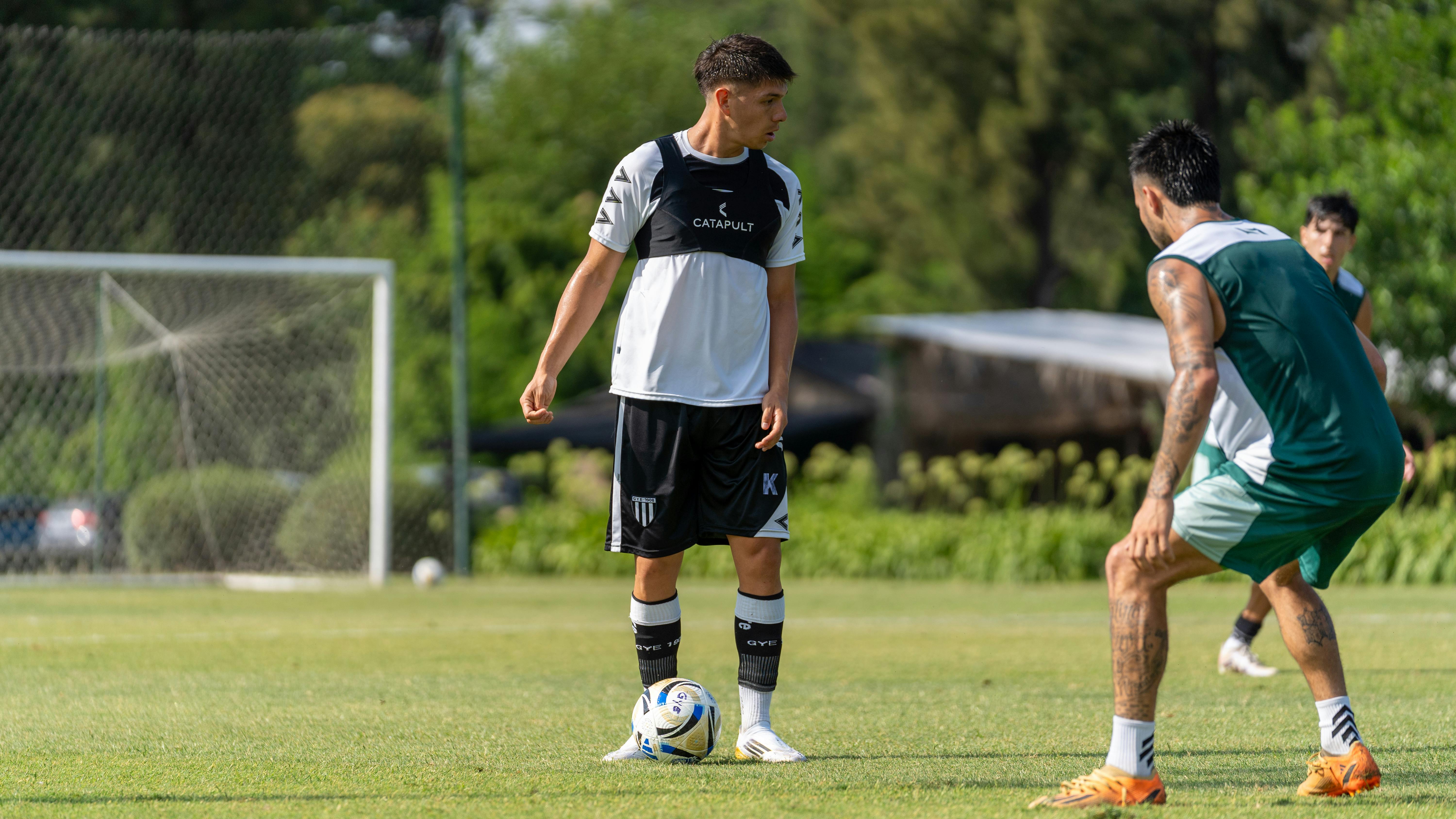 A dynamic soccer training session with young athletes in action on an outdoor grass field.