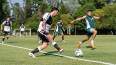 Action-packed soccer game with players competing on an outdoor field in bright daylight.