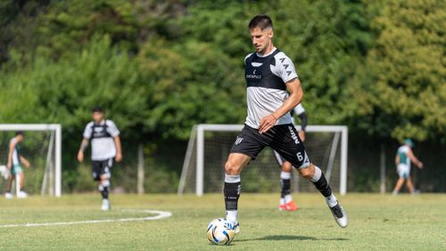 Free A soccer player is skillfully dribbling the ball on a sunny outdoor field during training. Stock Photo