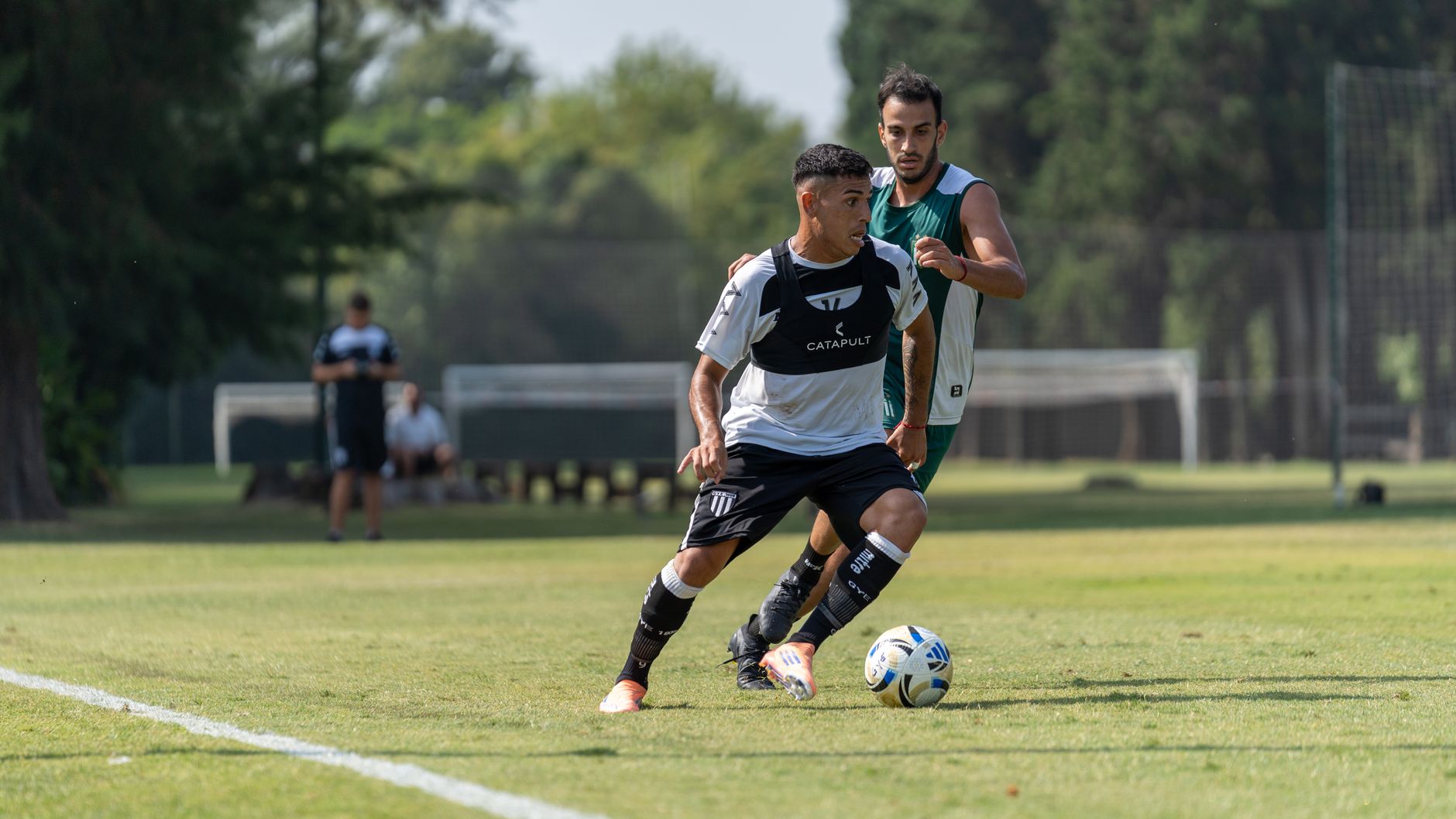 Two soccer players competing fiercely outdoors on a sunny day during a football match.
