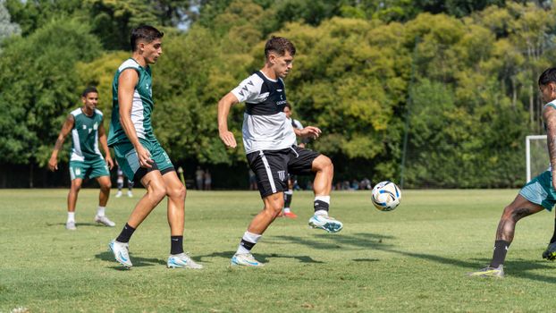 Dynamic action shot of soccer game capturing players in motion on a sunny day.