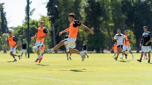 Free Youth soccer players training energetically outdoors under a clear sky. Stock Photo