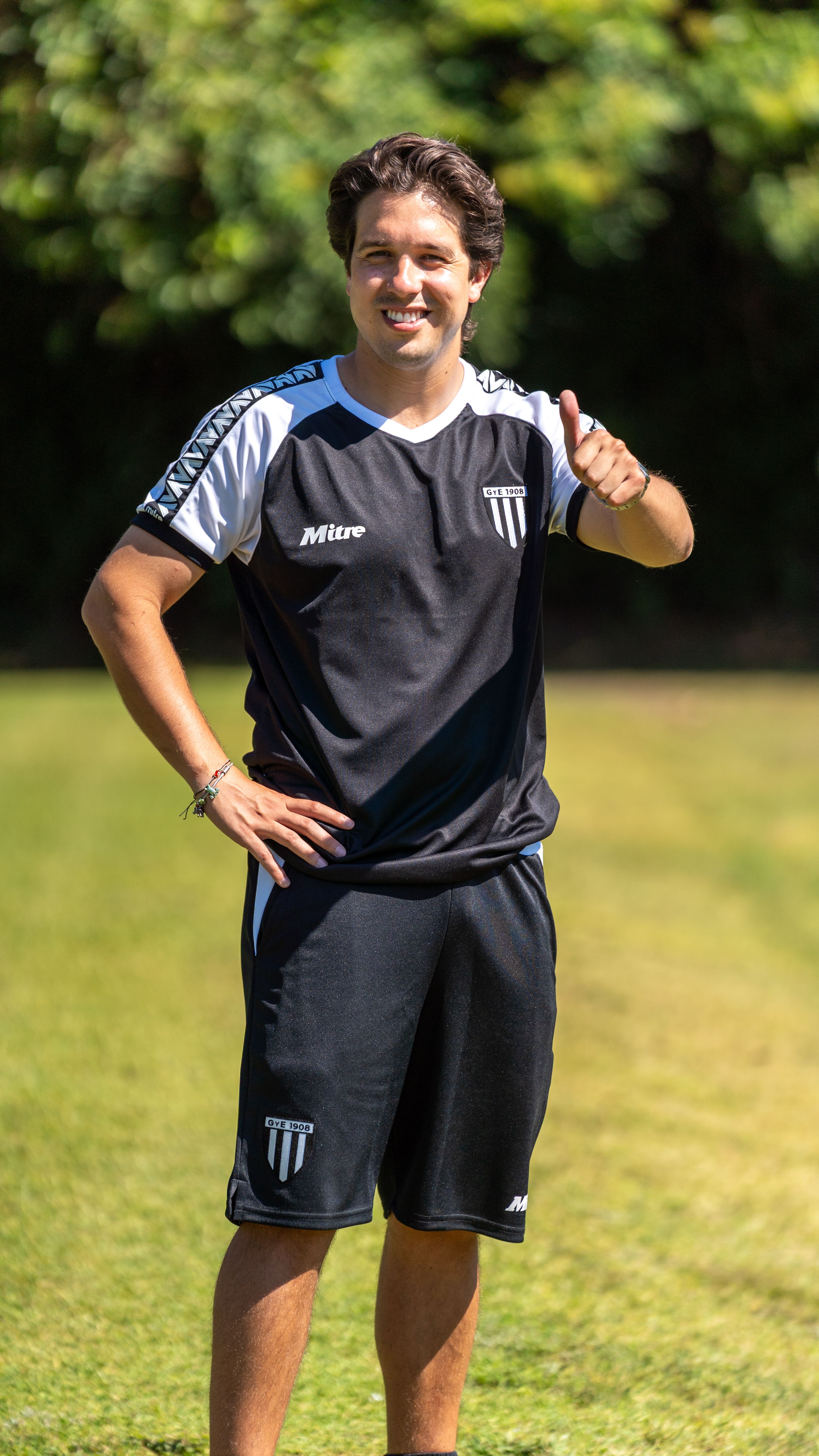 Happy athlete in sportswear giving a thumbs up on a sunny day outdoors.