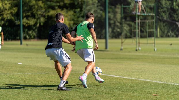 Players engaged in a soccer training session on a sunny outdoor field.