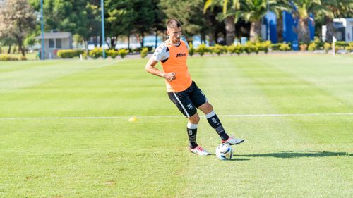 Free A male soccer player in action during a sunny outdoor training session on a grass field. Stock Photo