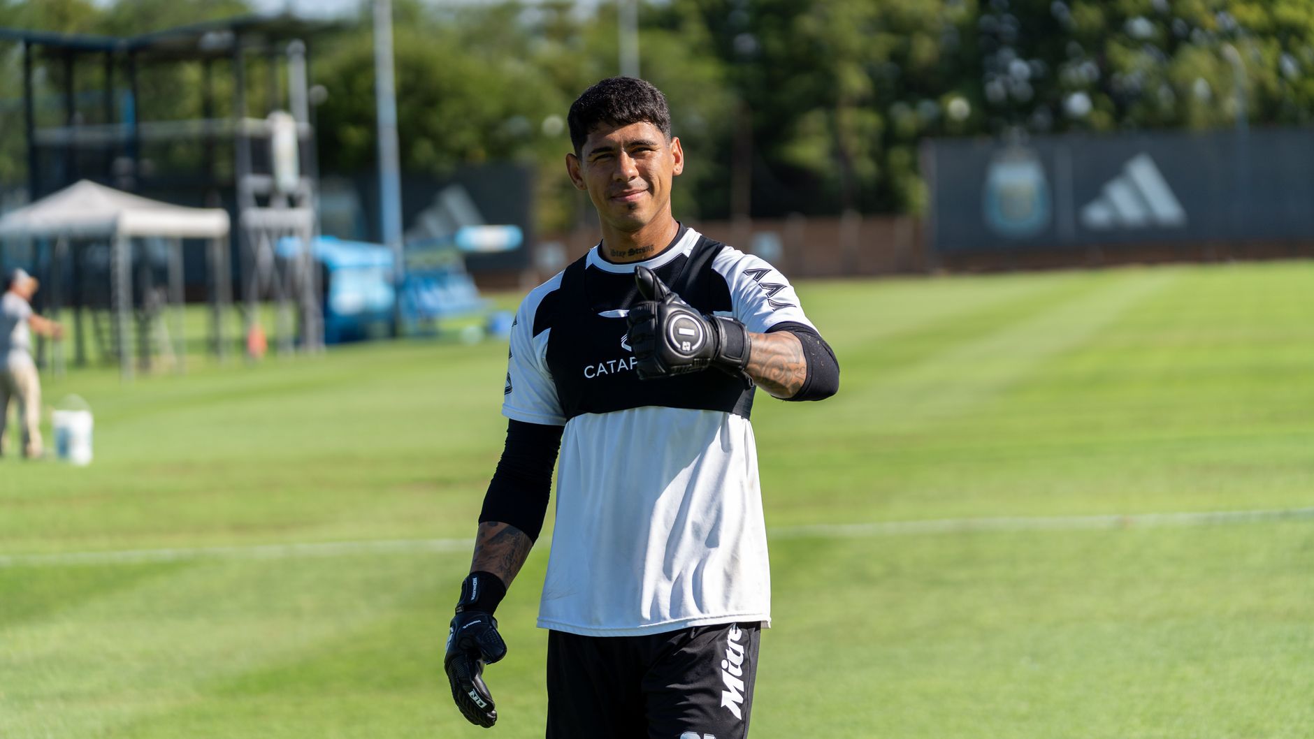 Young soccer player giving thumbs up on training field. Outdoor sports photography.