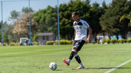 Free Male soccer player dribbling on a sunny field during daytime practice. Stock Photo