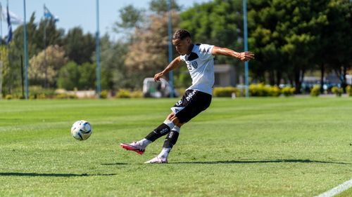 Free Dynamic action shot of a soccer player skillfully kicking a ball on a sunny day. Stock Photo