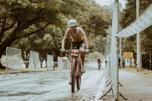 Free A determined cyclist pushes through rain during a triathlon, showcasing resilience. Stock Photo