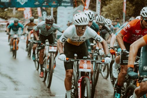 Free Cyclists in a competitive road race pedaling hard under rainy conditions. Stock Photo