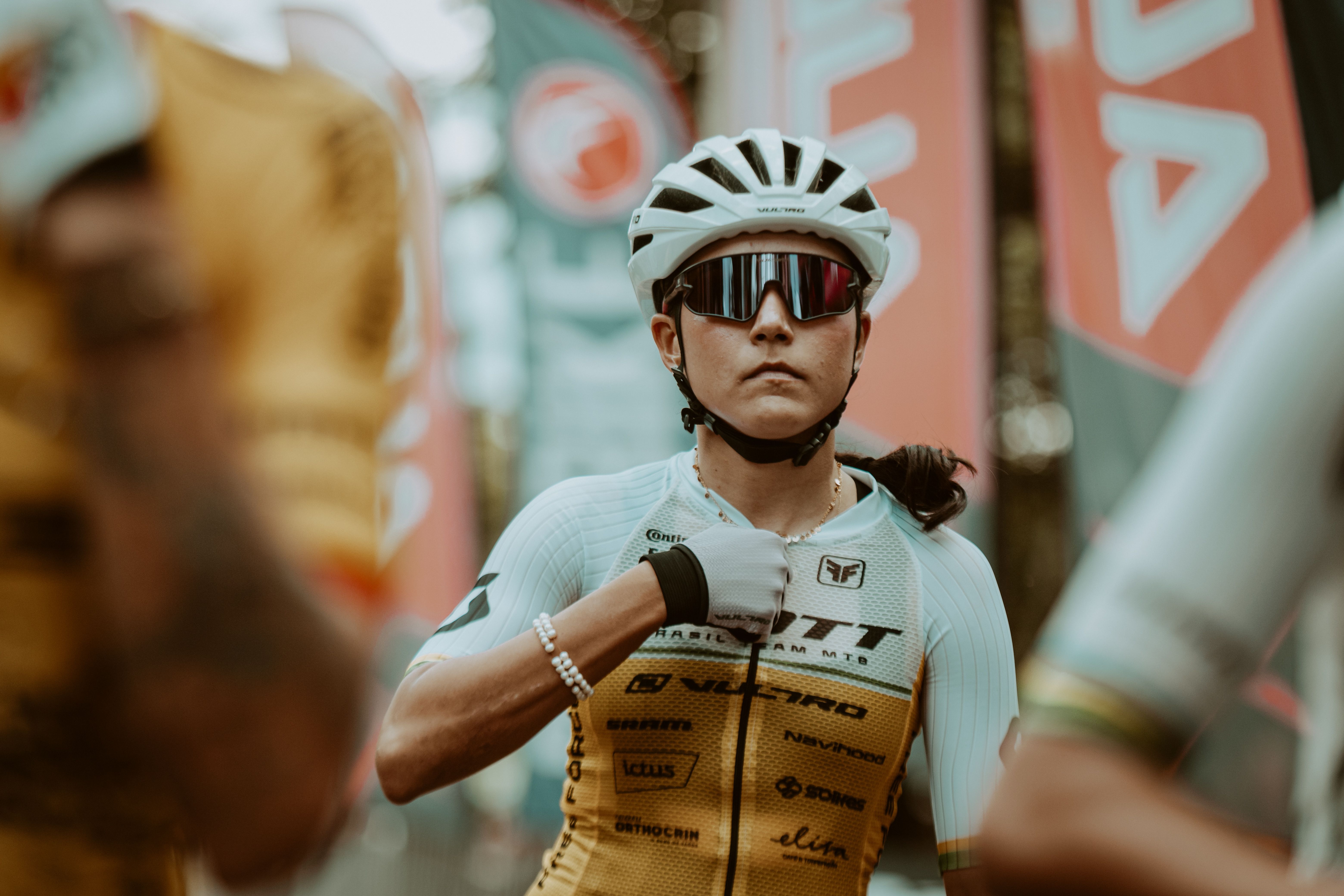 A determined female cyclist checks her equipment in preparation for a race.