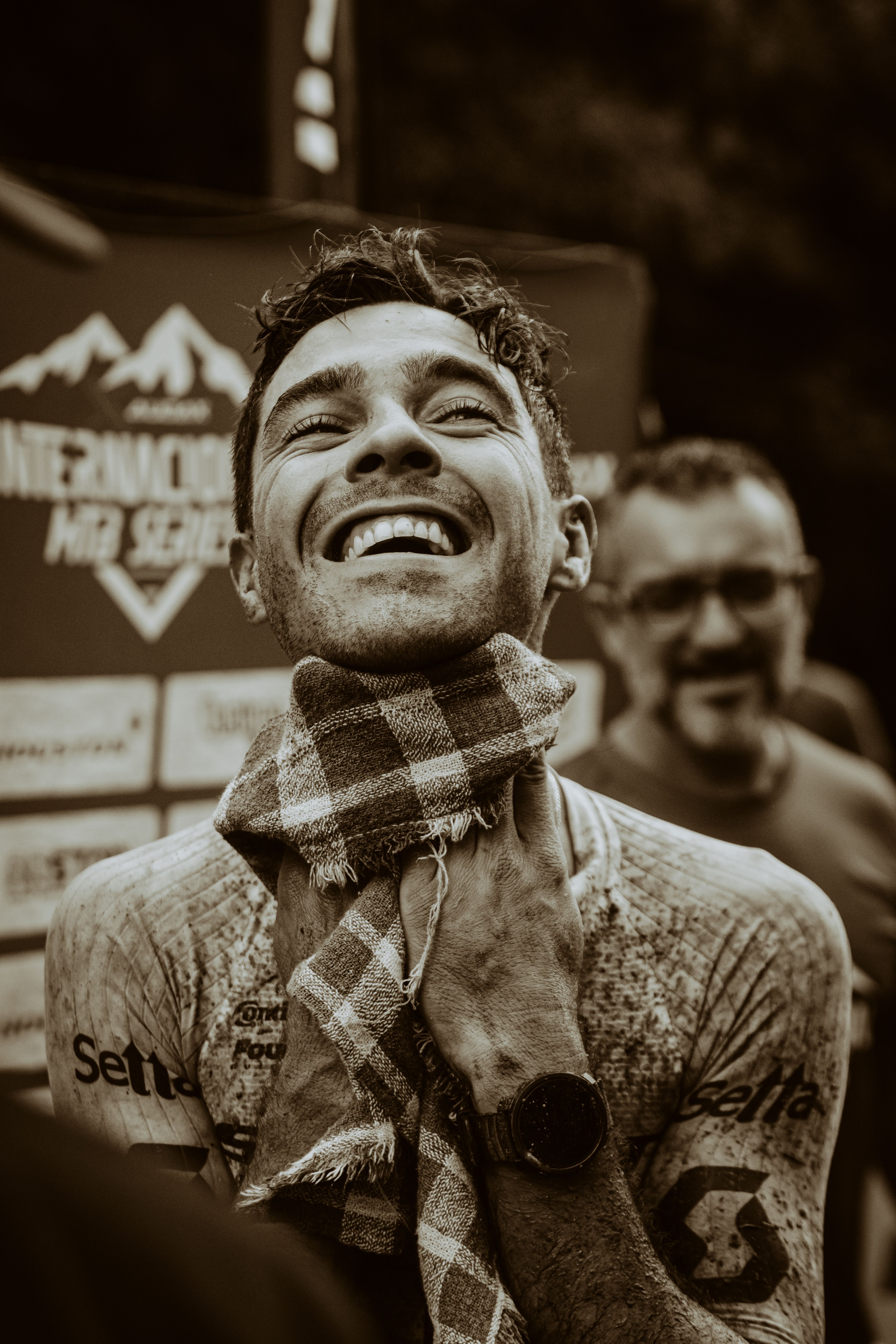 Cyclist joyfully celebrates post-race, embodying triumph and relief.