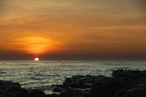 Free Captivating sunset at Cửa Tùng beach, Vietnam with vibrant orange skies and calm sea. Stock Photo