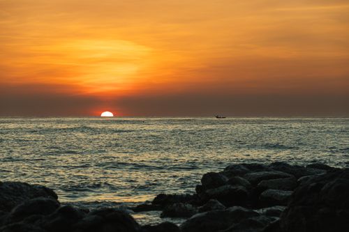 Free Stunning sunset view over the ocean in Cửa Tùng, Quảng Trị, Vietnam, with an orange sky reflecting on the water. Stock Photo