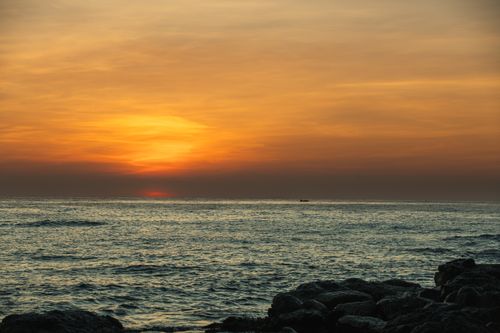 Free Breathtaking sunset view over Cửa Tùng beach with vibrant orange hues and calm ocean waves. Stock Photo