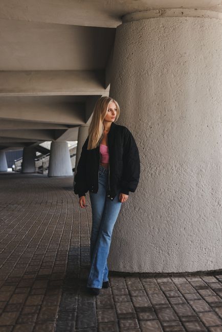 Stylish woman stands confidently in an urban architectural environment