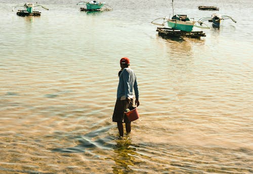 Pria Berdiri Di Tepi Laut Sambil Memegang Ember