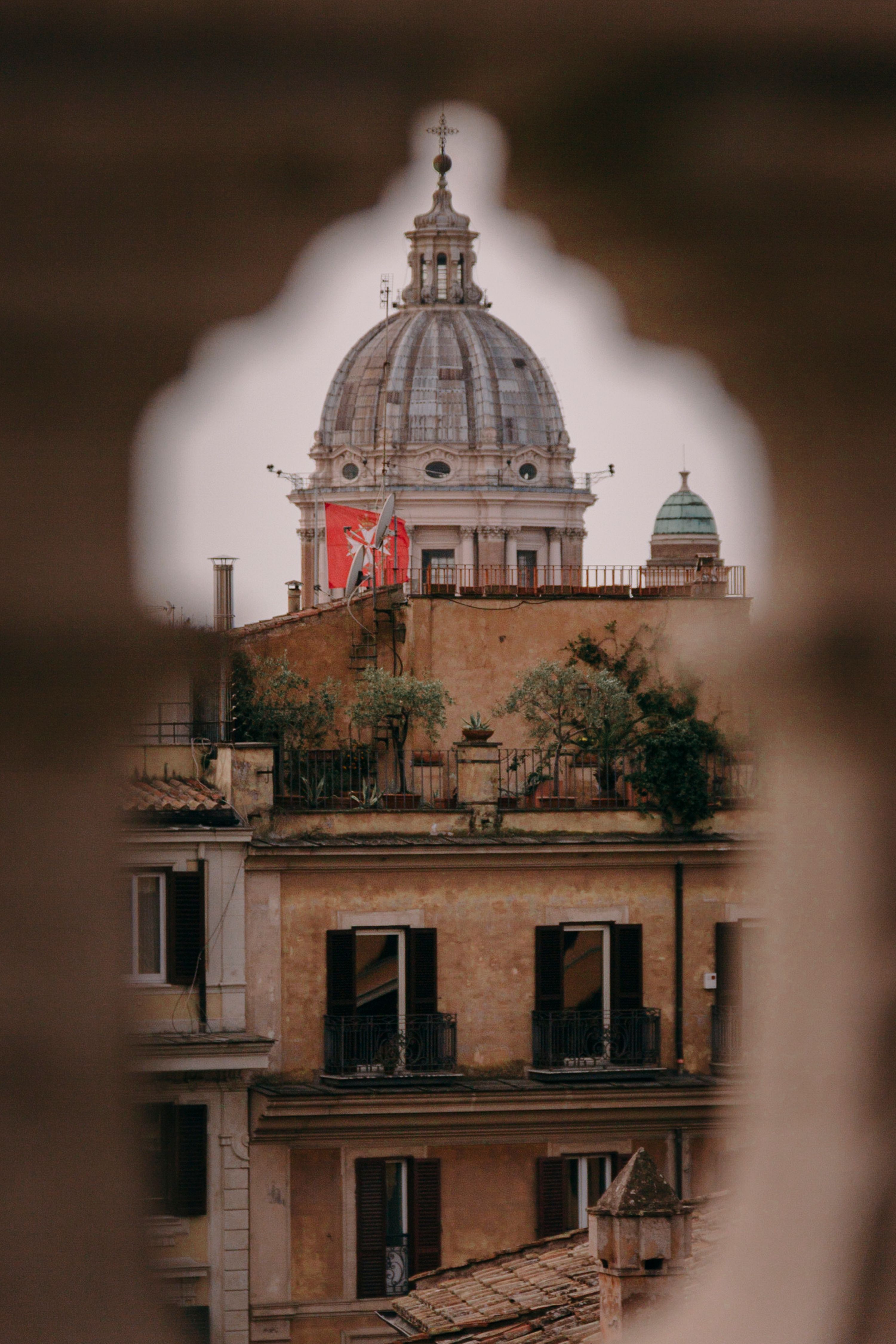 Captivating view of a Roman dome framed by historic architecture, showcasing timeless beauty.