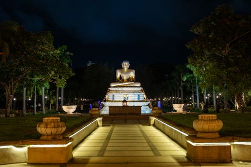 Free Illuminated Buddha statue at Seema Malaka Temple, Colombo, during a serene night, surrounded by lights and nature. Stock Photo
