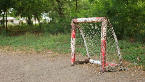 Free A rustic red goal post stands in a forested area, showcasing natural beauty and simplicity. Stock Photo