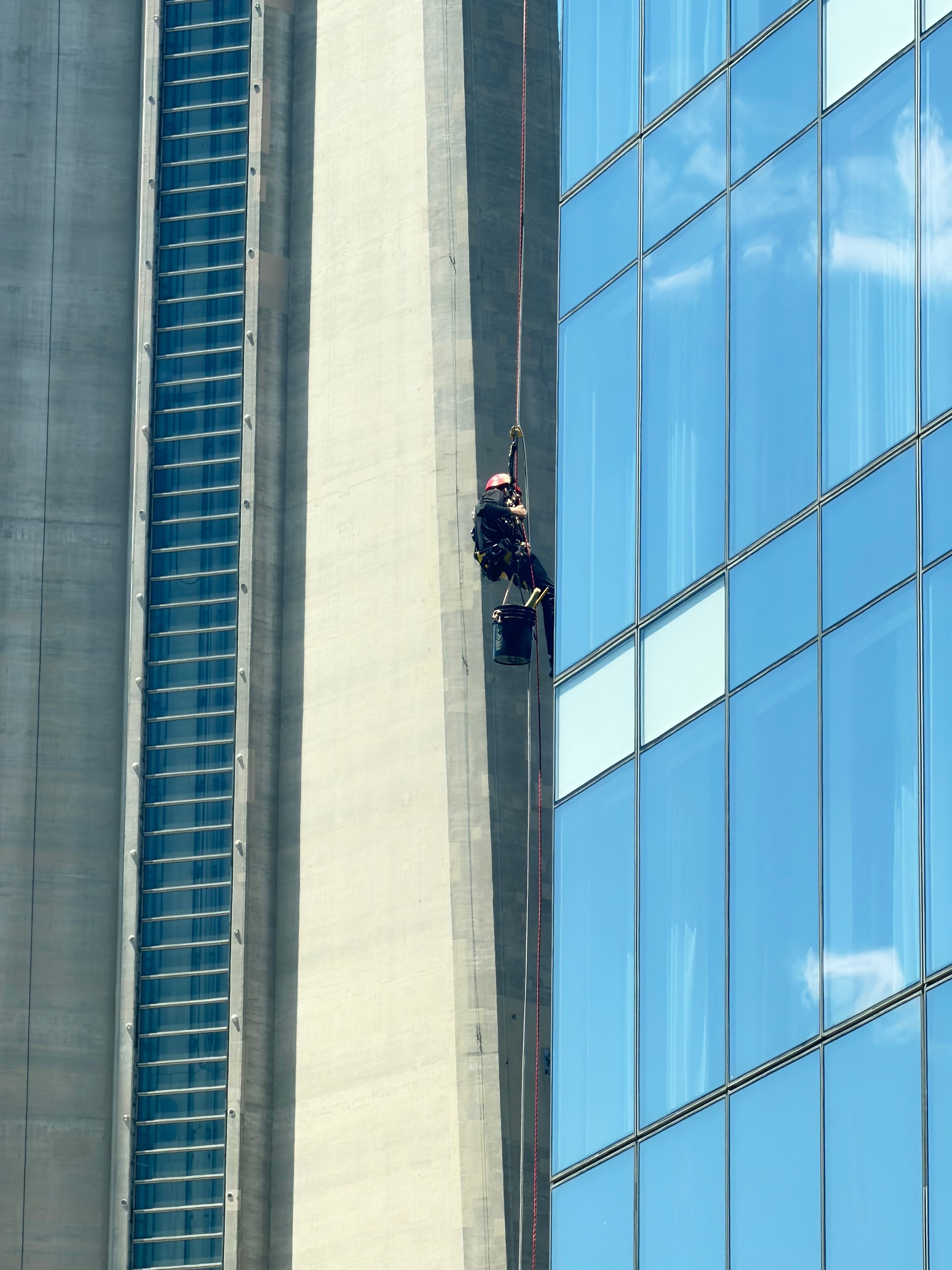A worker uses rope access techniques on a skyscraper in Toronto, Canada.