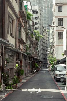 Quiet narrow alley in Taipei, Taiwan showcasing traditional urban architecture and vibrant greenery.