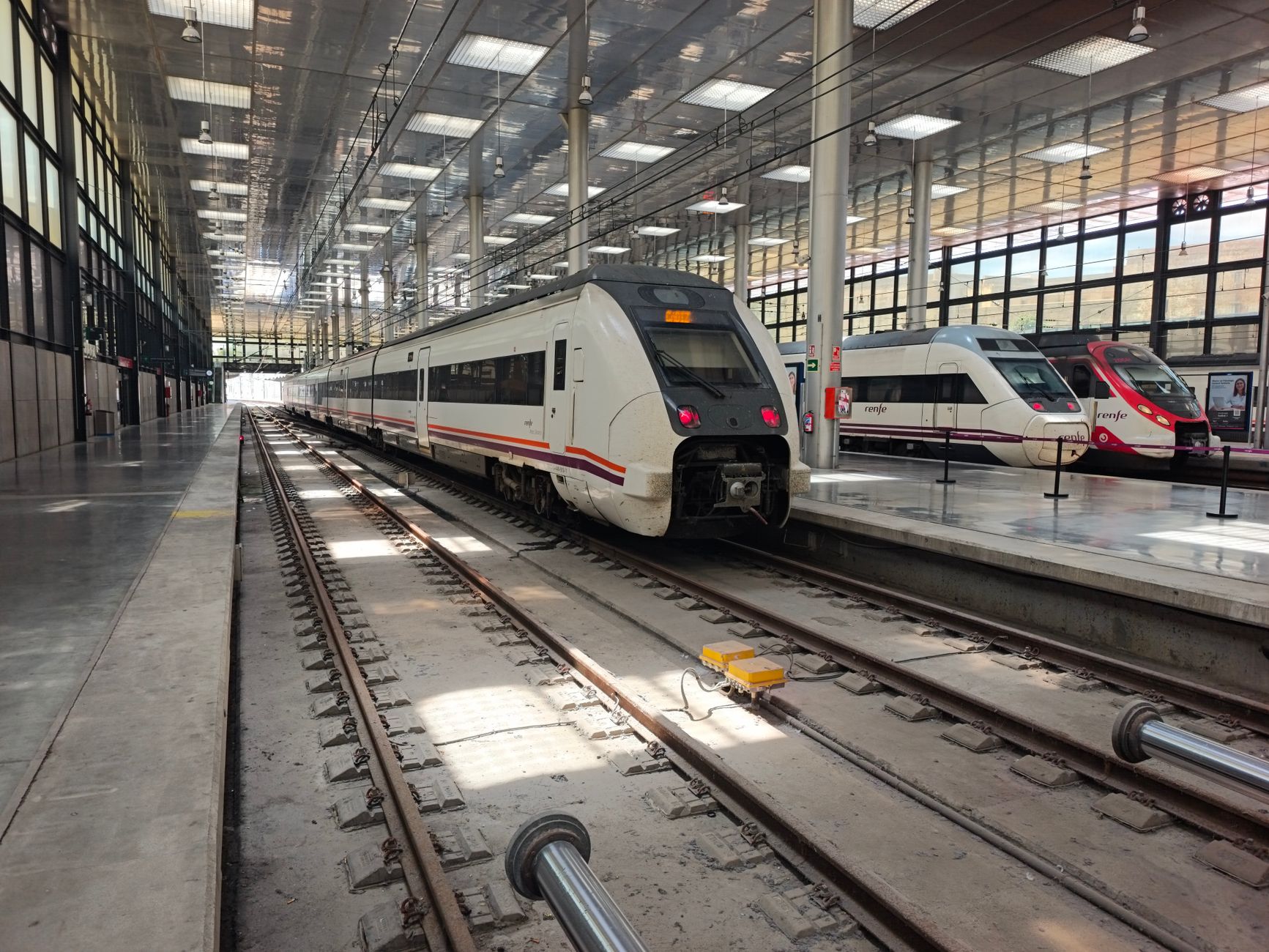 spain train travel guide – modern station in Cádiz, multiple trains on parallel tracks