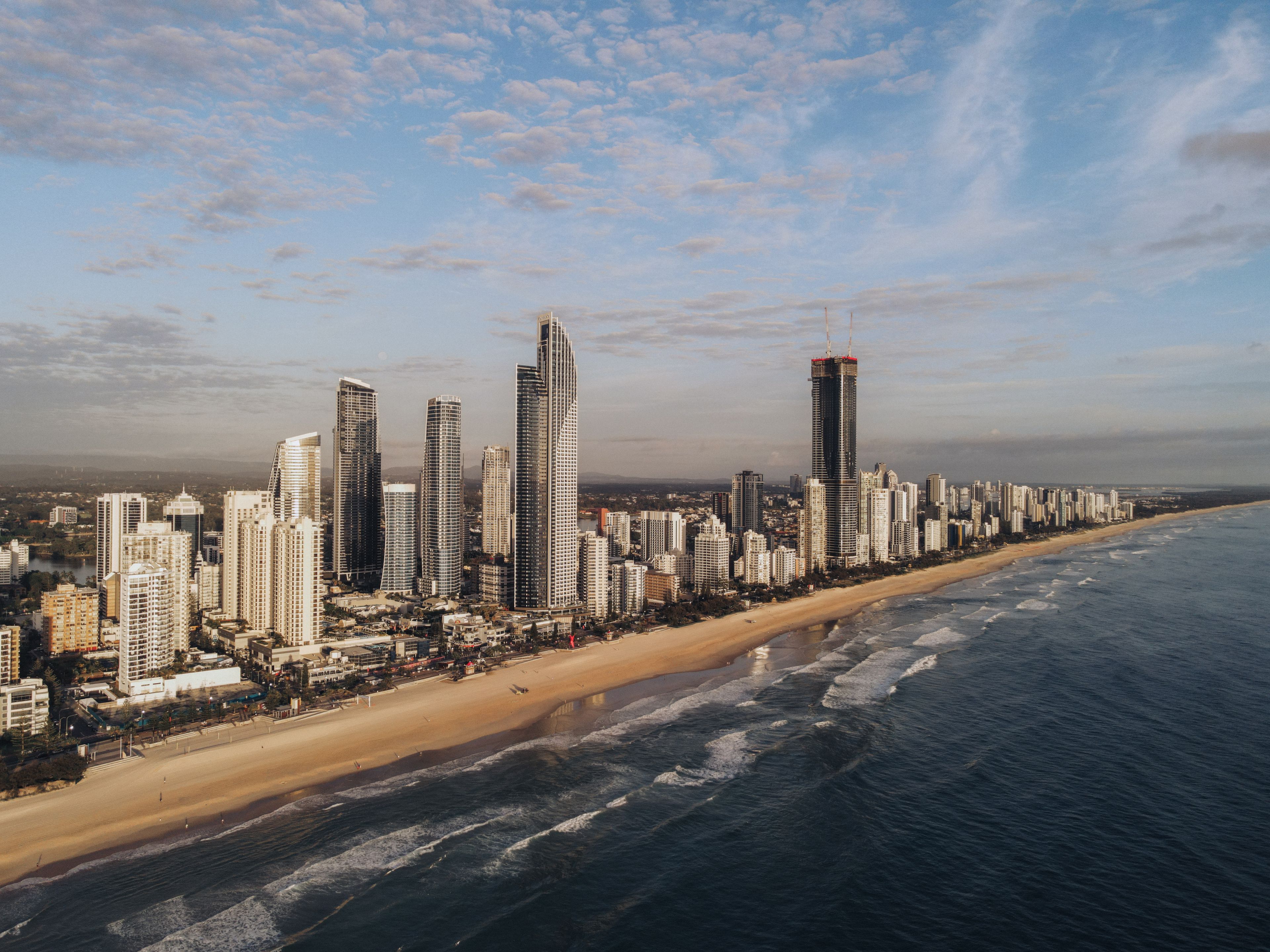 Stunning aerial image of Gold Coast's skyline along the beach at sunrise.