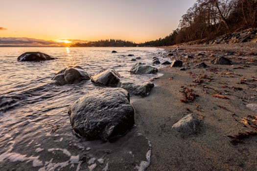 Tranquil sunrise over Comox Bay's rocky shores, showcasing nature's beauty on Vancouver Island.