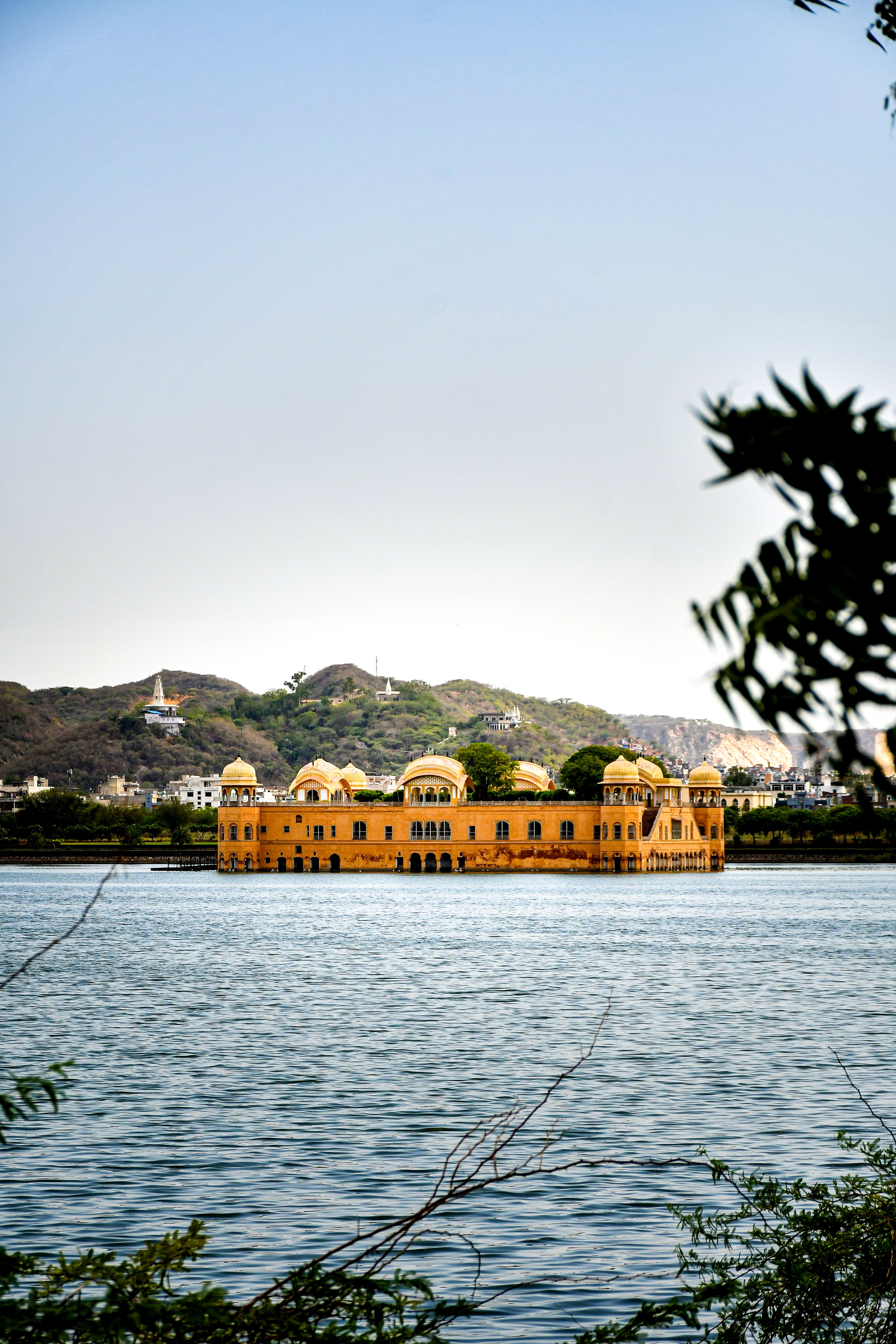 Beautiful shot of Jal Mahal in Jaipur, India with scenic lake and hills in the background.
